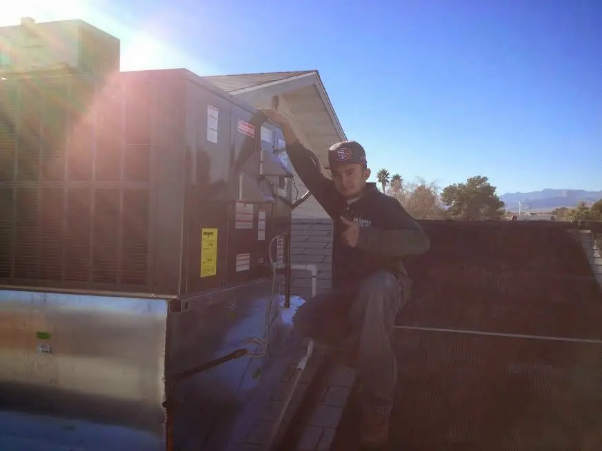 HVAC technician performing AC Tune-Up on a rooftop unit in Sweetwater